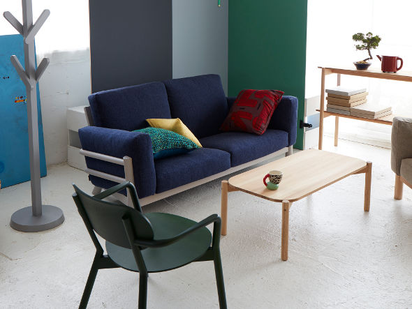 Fauteuil bas Castor vert face à un canapé bleu, avec portemanteau et table basse | Antifer