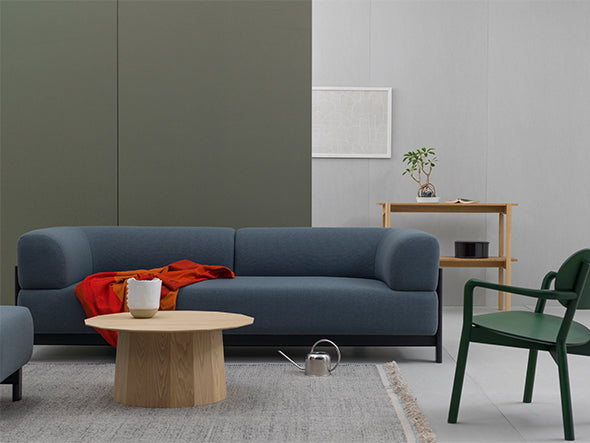 Fauteuil bas Castor vert dans un salon à canapé gris-bleu, avec table basse ronde | Antifer