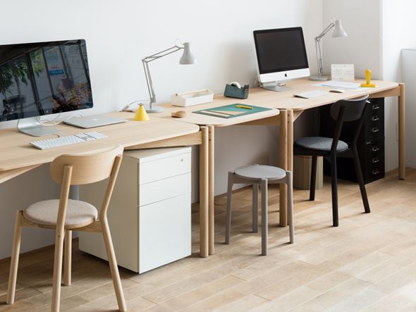 Tabourets Castor Plus gris rangés sous les bureaux d'un plateau en chêne | Antifer