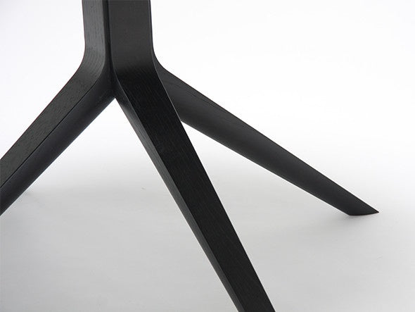 Table bistrot Scout — détail du piétement tripode en chêne teinté noir, vu depuis le sol | Antifer