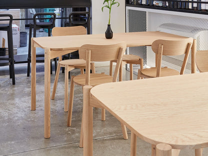 Chaises Castor autour des tables d'un showroom, plateaux en chêne au premier plan | Antifer