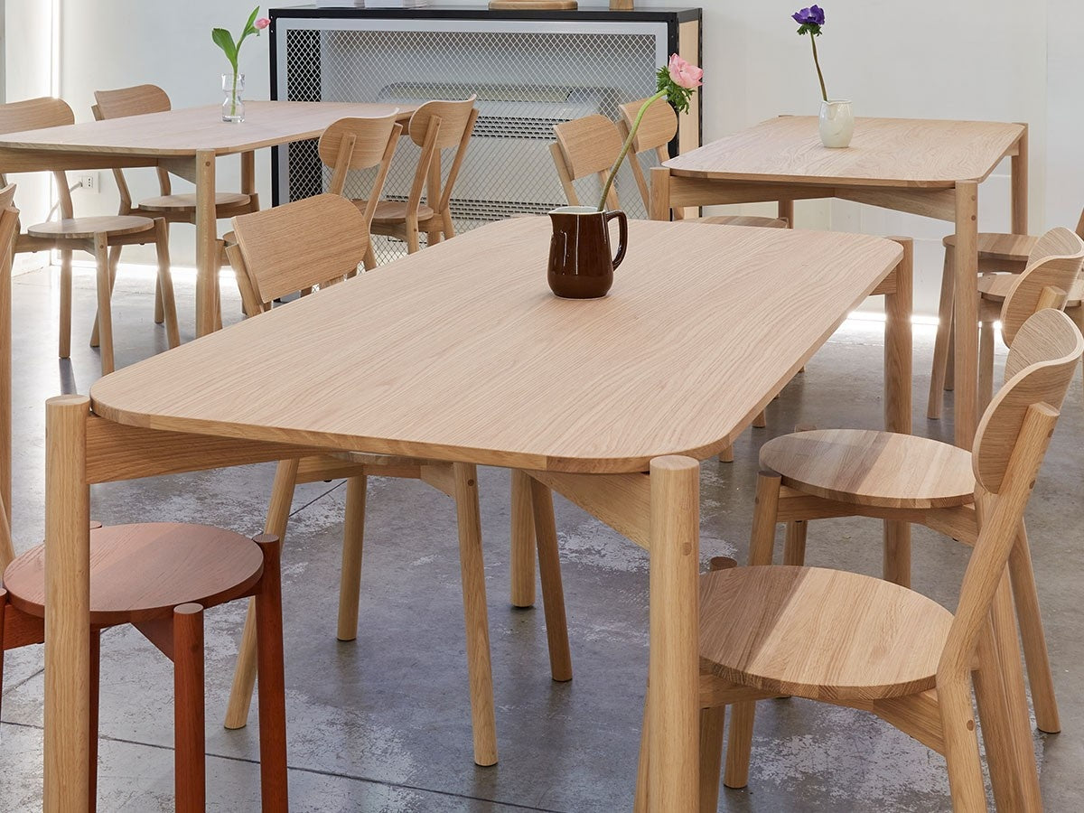 Chaises Castor autour d'une table de showroom, avec vase et bouquet | Antifer