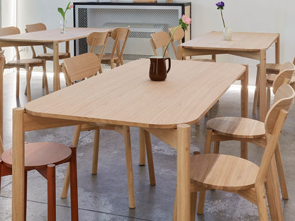 Chaises Castor autour d'une table de showroom, avec vase et bouquet | Antifer