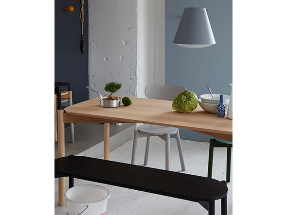 Banc de table Castor noir glissé sous une table en chêne, dans une cuisine ouverte | Antifer