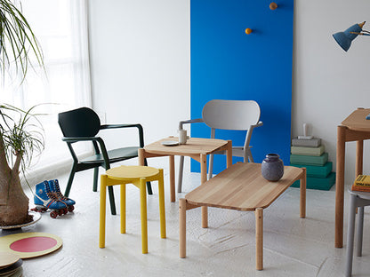 Tabouret Castor Plus jaune devant un mur bleu, avec fauteuils Castor et table basse | Antifer