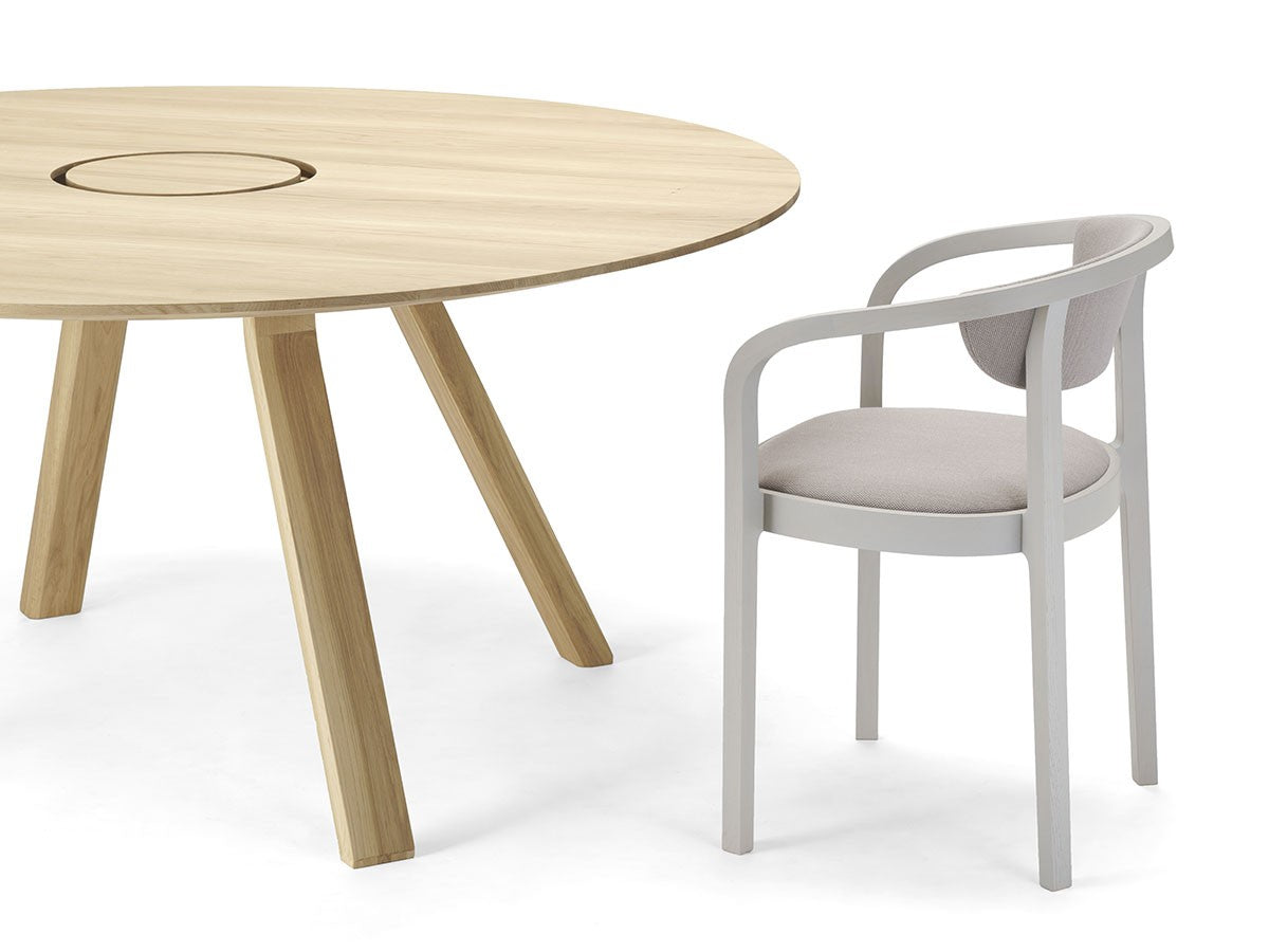 Table ronde Spectrum ST 160 en chêne avec chaise Chesa grise de trois quarts, Geckeler Michels — vue studio n°3 | Antifer