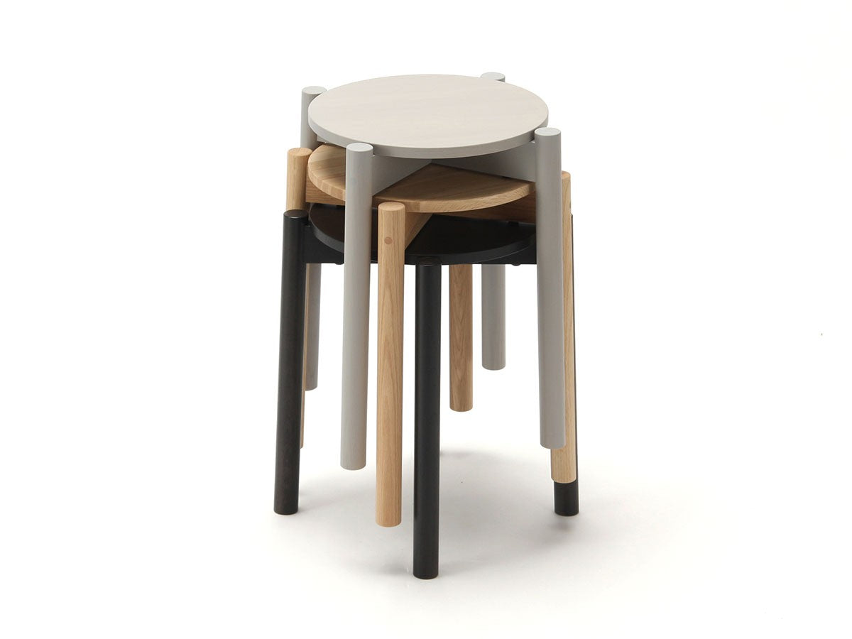 Quatre tabourets Castor Plus empilés, finitions blanche, noire, grise et chêne — vue studio n°11 | Antifer