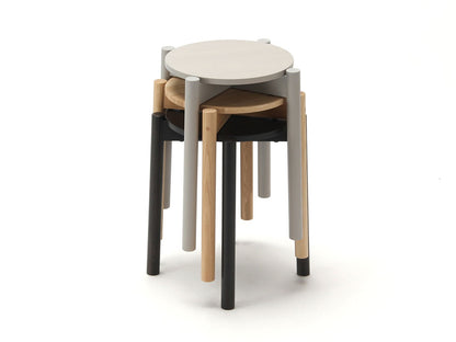 Quatre tabourets Castor Plus empilés, finitions blanche, noire, grise et chêne — vue studio n°11 | Antifer