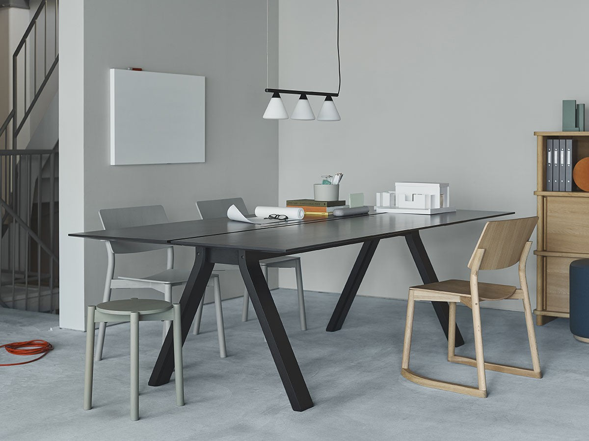 Tabourets Castor Plus gris empilés près d'une table de réunion noire, dans un bureau | Antifer