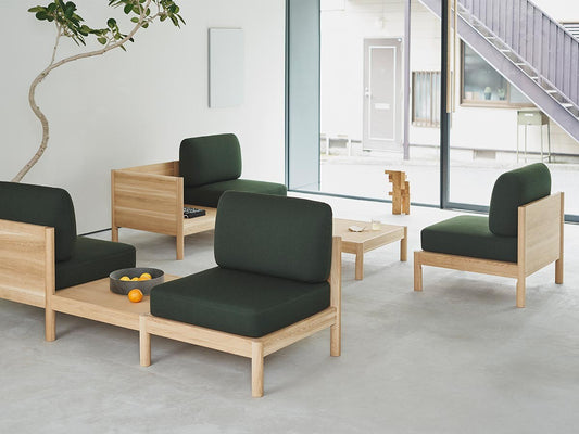 Modules Castor Lobby Sofa à coussins verts dans un hall vitré, avec guéridon et arbre | Antifer
