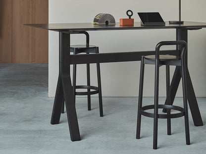 Tabourets de bar Castor noirs le long d'un comptoir haut, dans un intérieur en béton | Antifer