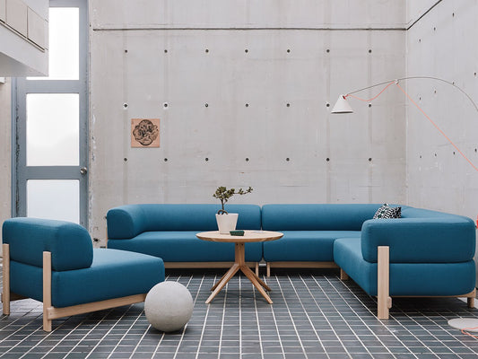 Composition Elephant bleue en angle dans un loft en béton, avec guéridon et pouf | Antifer
