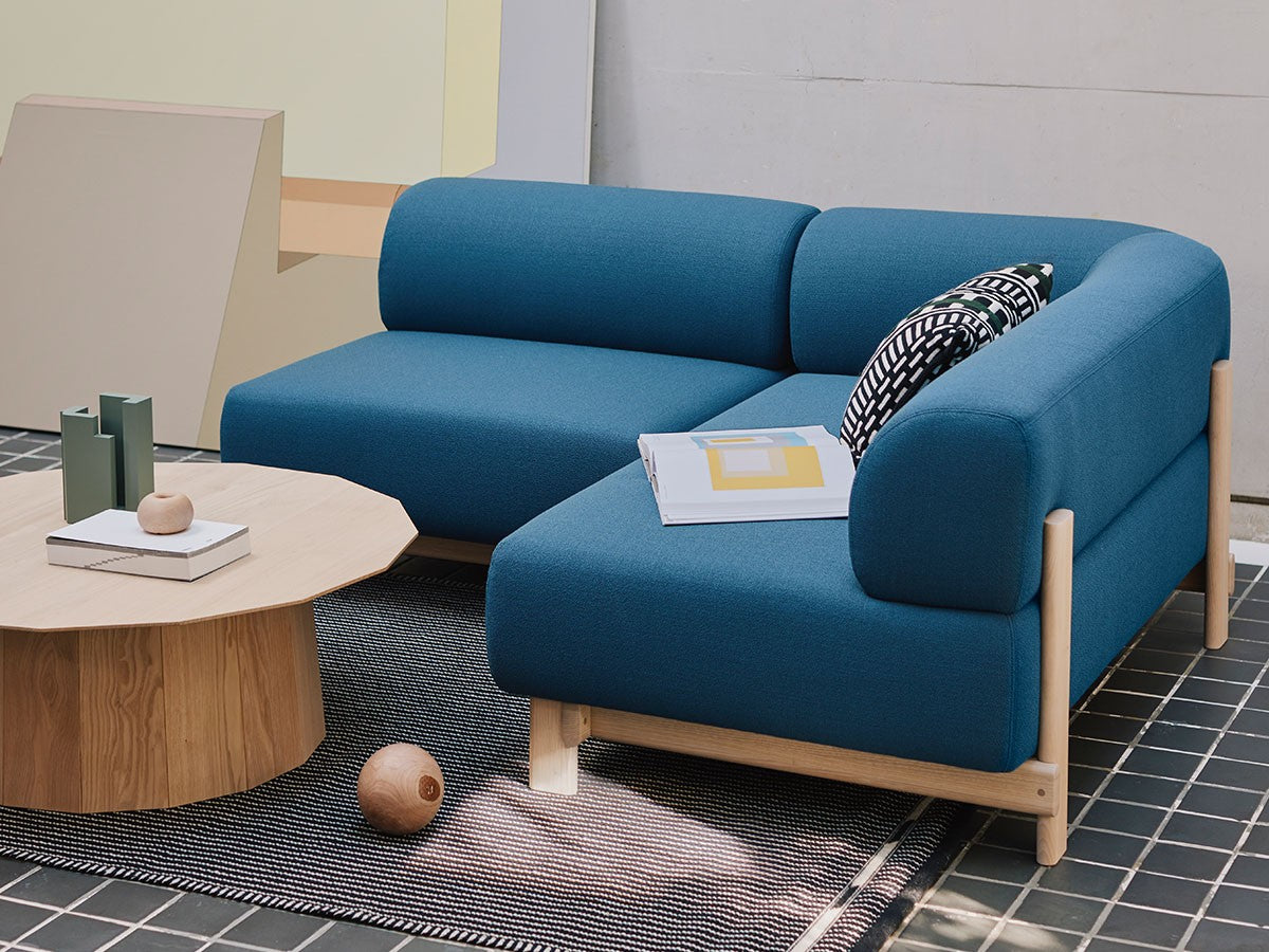 Méridienne Elephant bleue et table basse ovale sur un tapis, dans un loft en béton | Antifer