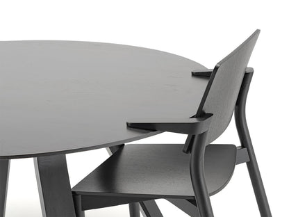 Table ronde Spectrum ST 120 — détail du plateau noir et d'une chaise Chesa noire glissée dessous | Antifer