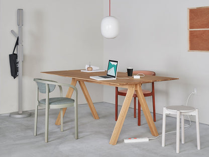 Tabouret Castor Plus blanc dans un bureau clair, avec table en chêne et portemanteau Signs | Antifer