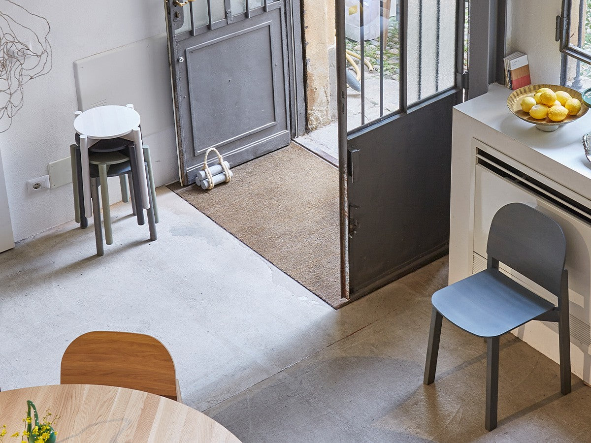 Tabourets Castor Plus gris empilés dans une entrée, avec chaise bleue et console | Antifer