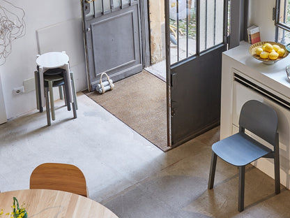 Tabourets Castor Plus gris empilés dans une entrée, avec chaise bleue et console | Antifer