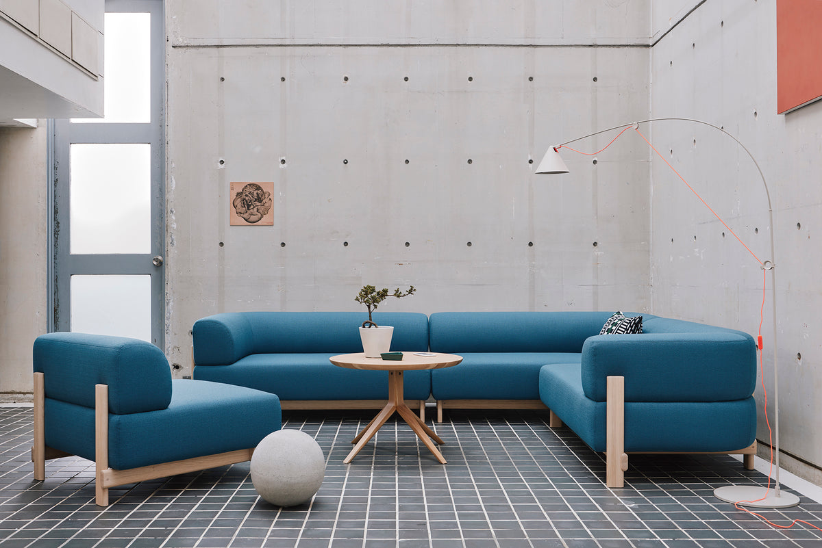 Modules Elephant bleus alignés dans un intérieur en béton, avec guéridon et lampe articulée | Antifer