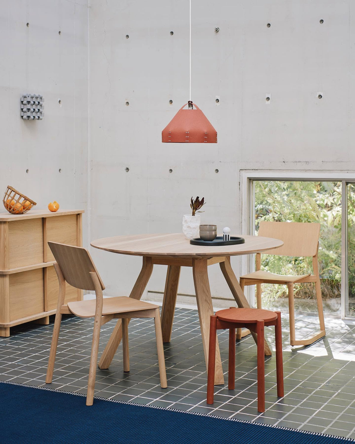 Chaises Panorama en chêne autour d'une table ronde, dans une salle à manger en béton — Karimoku New Standard | Antifer