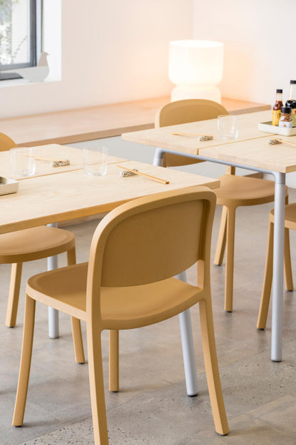 Chaises Emeco 1 Inch Reclaimed sable en restaurant avec tables Run — design Jasper Morrison | Antifer