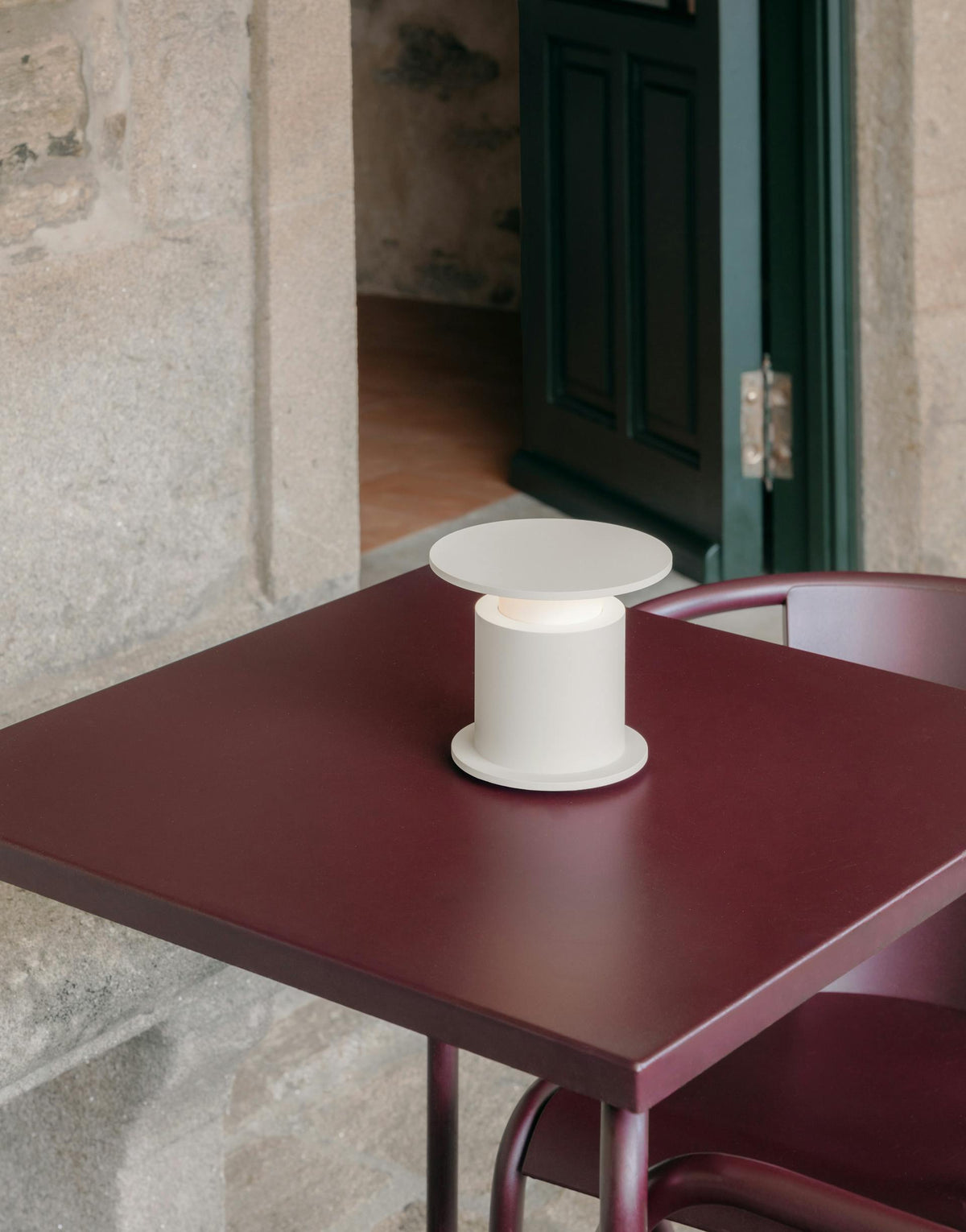 Gros plan lampe nomade w241 Faro blanche sur table bordeaux — design David Chipperfield Wästberg | Antifer