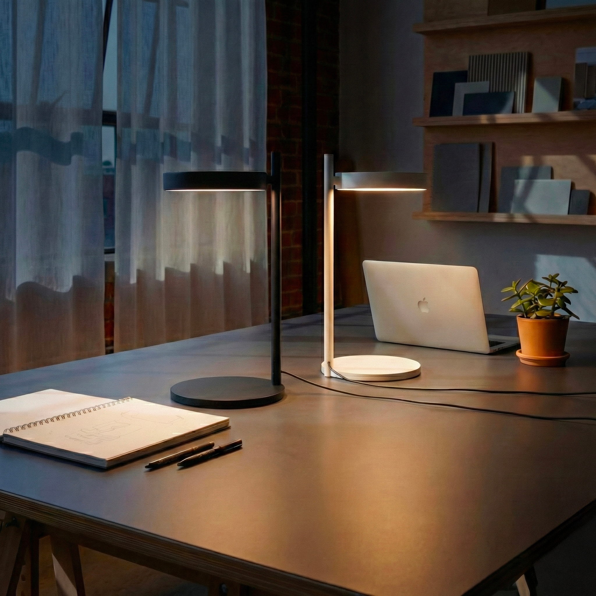 Lámpara Pastille de Wästberg iluminando un espacio de trabajo en un loft — iluminación de diseño de acento