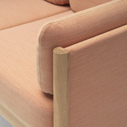 Canapé Castor Lobby Plus 2 places — détail de l'accoudoir en chêne et du coussin rose pâle | Antifer