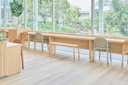 Bancs et chaises Castor le long d'un comptoir en chêne, dans une cafétéria vitrée | Antifer