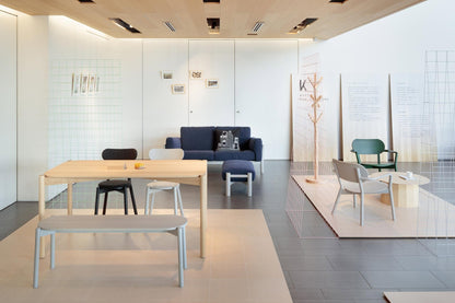 Portemanteau Signs en chêne sur l'estrade d'un showroom, canapé bleu et chaise Polar — vue n°2 | Antifer