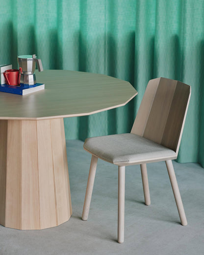 Table Colour Wood ø95 avec une chaise Colour Wood, sur fond de rideau vert — Karimoku New Standard | Antifer