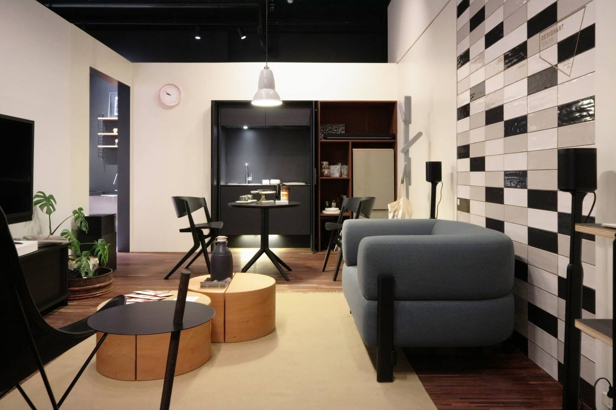 Canapé Elephant gris foncé dans un intérieur à mur damier, avec tables basses rondes | Antifer