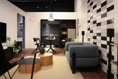 Canapé Elephant gris foncé dans un intérieur à mur damier, avec tables basses rondes | Antifer