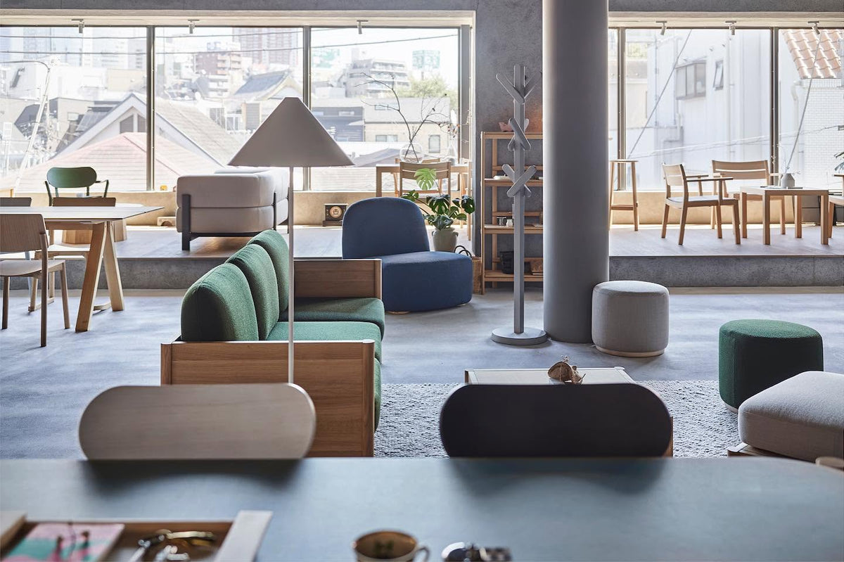 Canapés et poufs Elephant dans un showroom vitré, portemanteau Signs au second plan — Karimoku New Standard | Antifer
