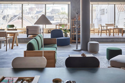 Canapés et poufs Elephant dans un showroom vitré, portemanteau Signs au second plan — Karimoku New Standard | Antifer