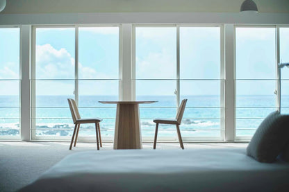 Table bistrot Scout et deux chaises Castor devant la baie vitrée d'une chambre face à la mer | Antifer