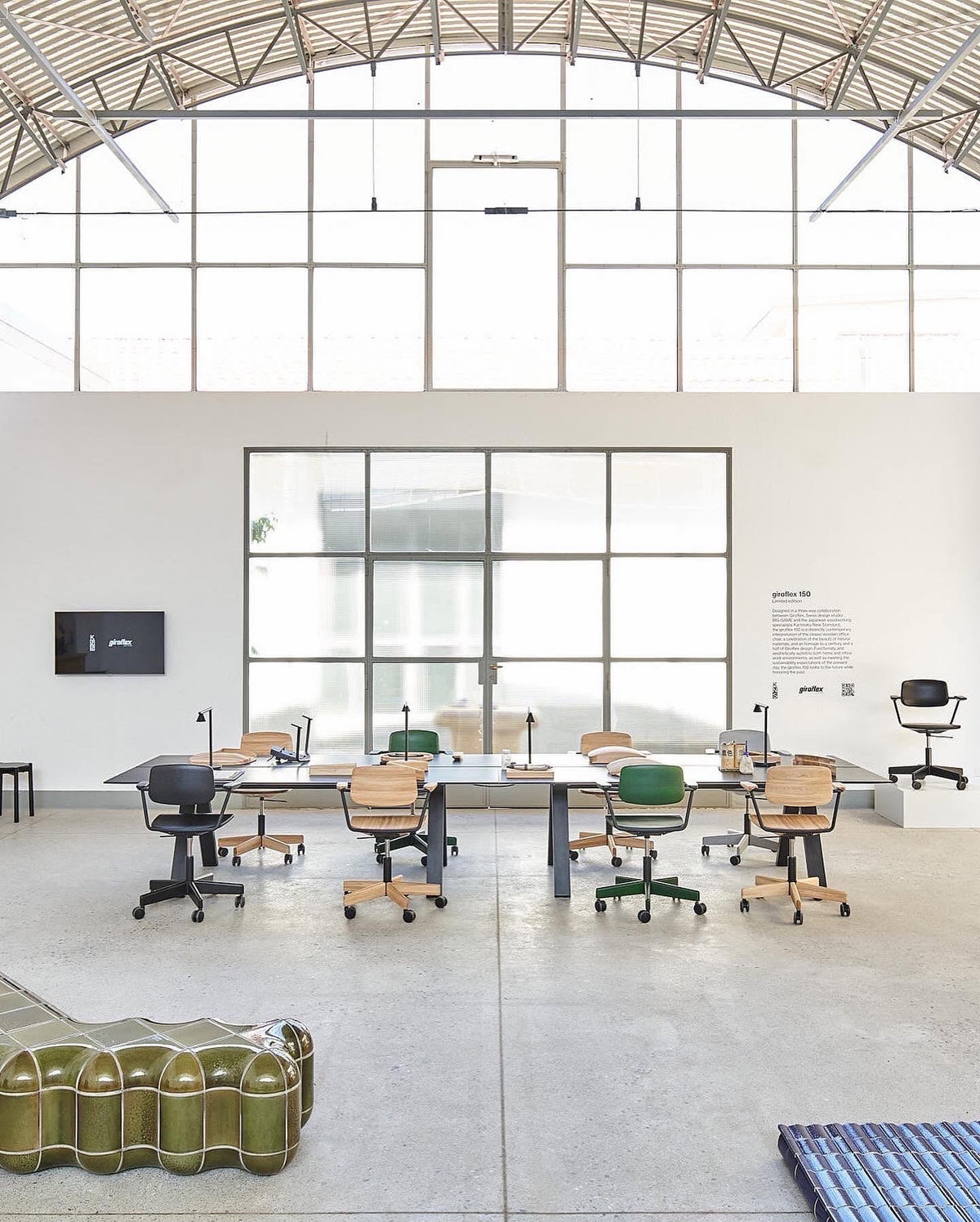Bureau Spectrum noir sous la charpente d'un hangar réhabilité, avec sièges à roulettes — Karimoku New Standard | Antifer