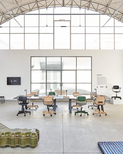 Bureau Spectrum noir sous la charpente d'un hangar réhabilité, avec sièges à roulettes — Karimoku New Standard | Antifer