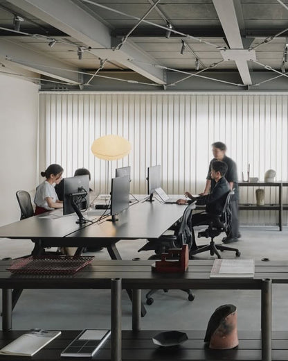 Bureaux Spectrum noirs en open space, écrans et lampes, plusieurs personnes au travail — Karimoku New Standard | Antifer