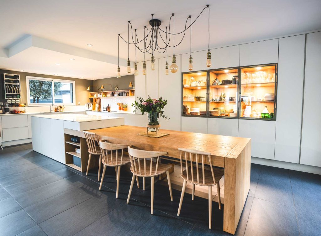 Cuisine sur mesure avec table en bois brut et plan de travail en céramique